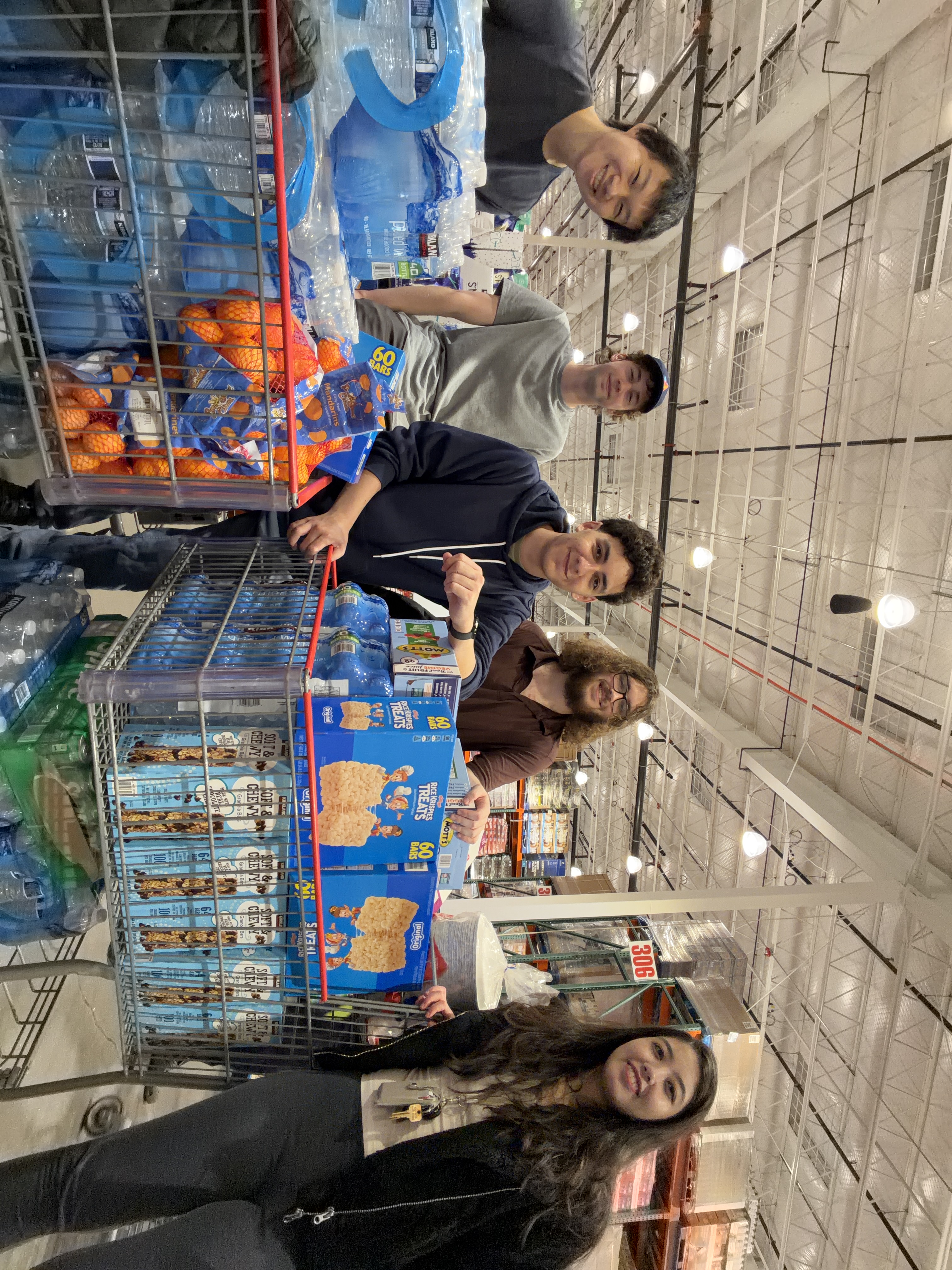 George, Chris, Andrew, Ben, and Grace smiling next to multiple Costco carts