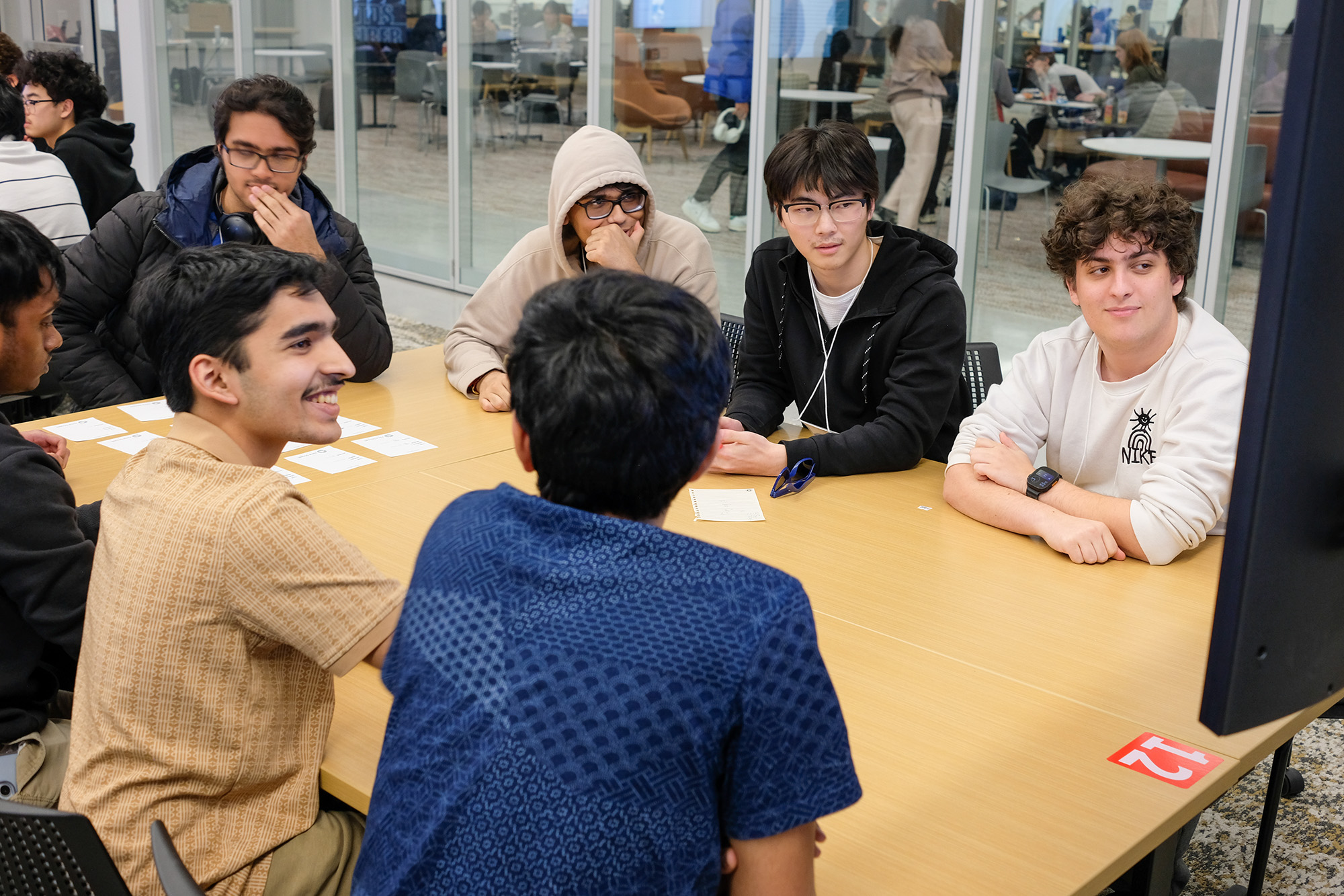 Estimathon participants discussing questions while looking at a monitor